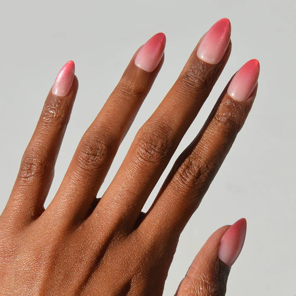 Faded Feelings press-on nails in soft faded pink shades with almond shape stylish nail set on hand close-up
