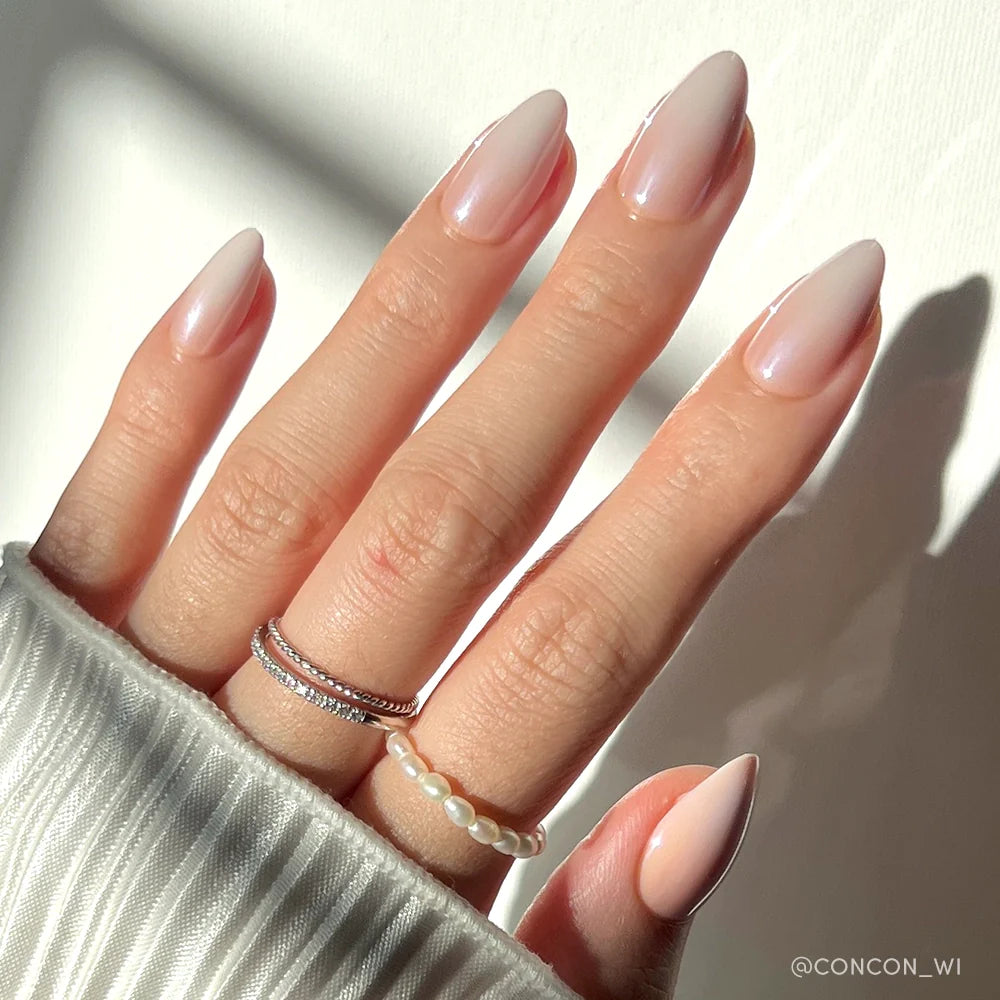 Fiancéd elegant press-on nails in soft nude shade showcasing almond shape and glossy finish on hand model