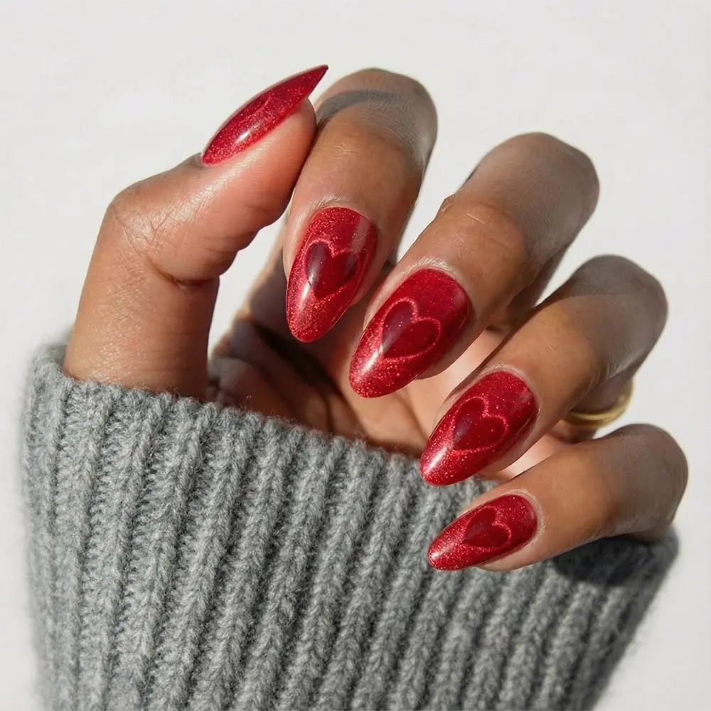 Sent with Love press-on nails featuring romantic red heart design on almond-shaped nails, styled on natural hands for feminin