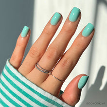 Soft teal press-on nails with glossy finish showcasing elegant almond nail shape on white background